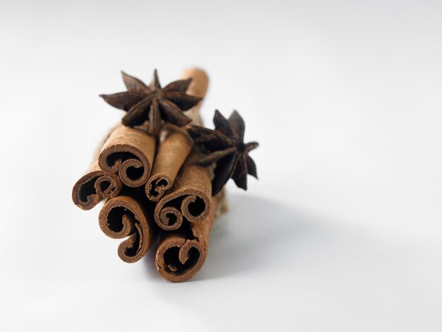 Photo close-up of cinnamons and star anise on white background