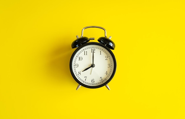 Close-up of clock against yellow background