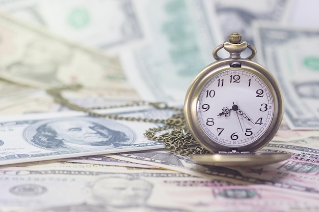 Photo close-up of clock on us paper currency