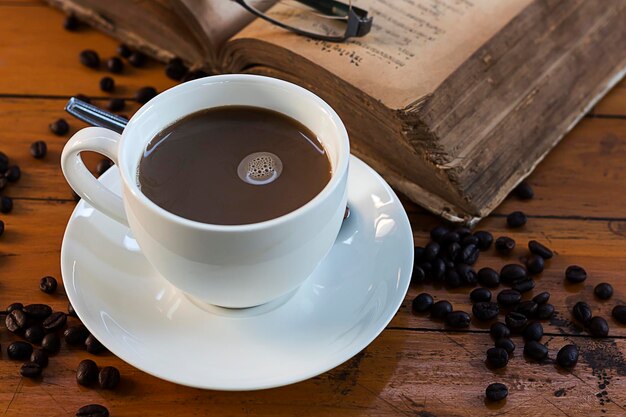 Close-up of coffee by book on table