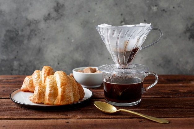 Close-up coffee with tasty croissant