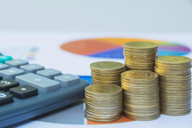 Close-up of coins by calculator and paper on table