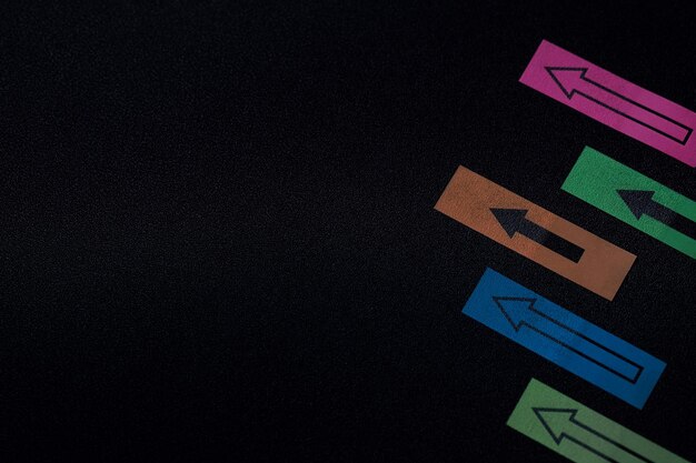 Photo close-up of colorful arrow signs on black wall