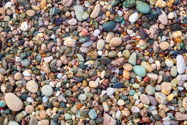 A close up of a colorful pebbles on a beach.