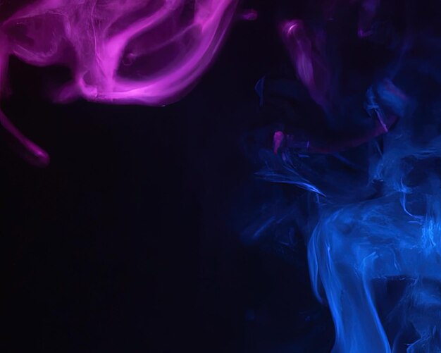 Close up of colorful pink and blue steam smoke in mystical and fabulous forms on black background mo