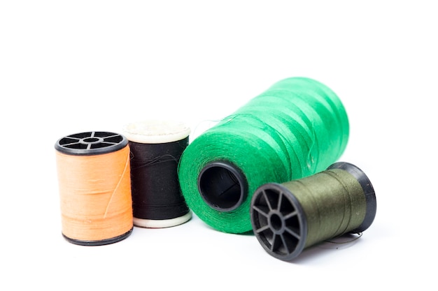 Photo close-up of colorful thread spools against white background