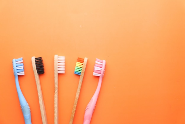 Close up of colorful tooth brush on orange space.