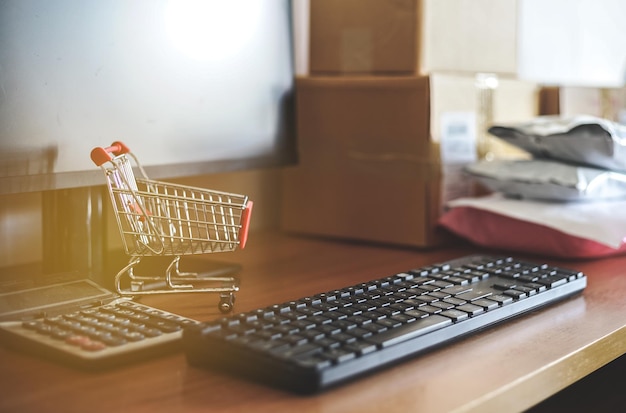 Close up of computer keyboard with small shopping cart calculator and Pakaging box