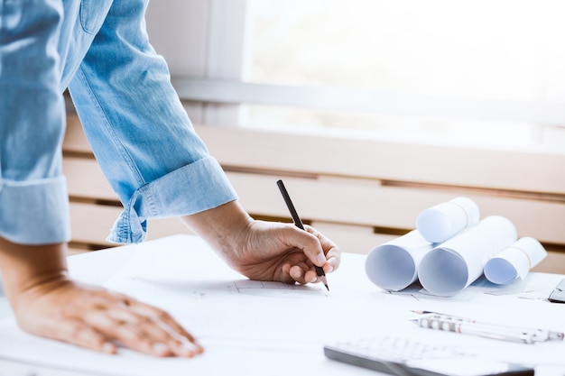 Close-up of confident architect female in casual wear working on desk. Concept building on project.