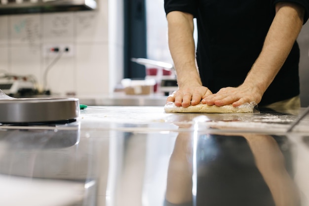 Close up The cook wraps the dough in cling film making macaroons or cakes