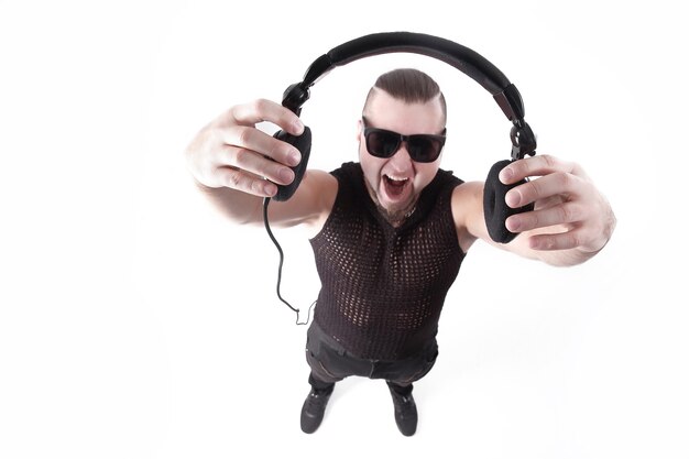 Close up.cool male rapper looks at the camera and shows the headphones.isolated on white.