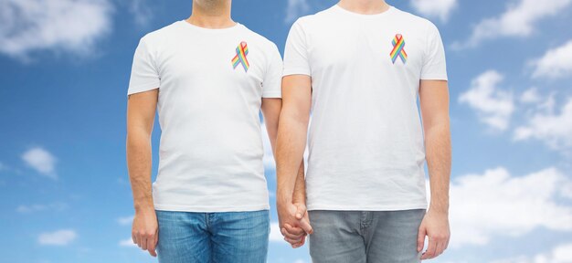 close up of couple with gay pride rainbow ribbons