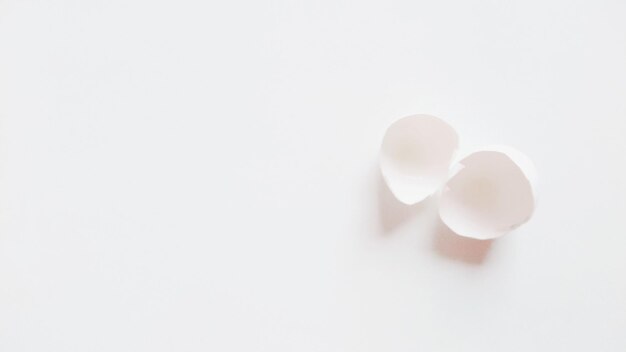 Photo close-up of cracked eggshell over white background