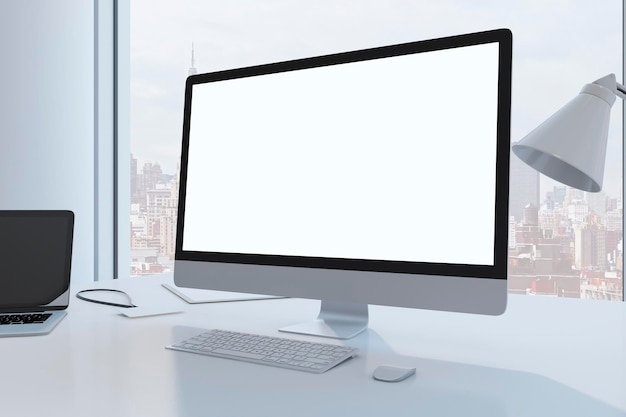 Close up of creative designer desktop with empty white mock up computer monitor laptop and supplies in modern office with window and panoramic city view 3D Rendering