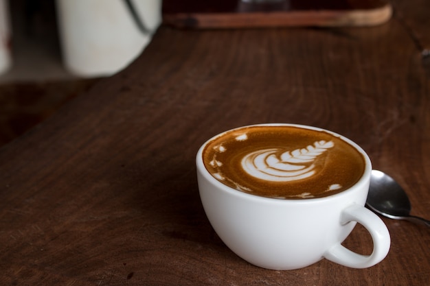 Close up of Cup of hot latte art coffee on wooden table