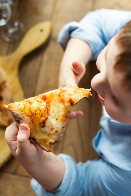 Close up cute kid eating pizza