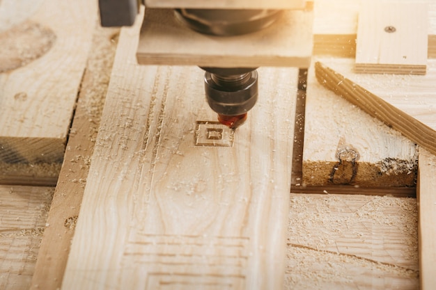 Close-up of cutting wood on a CNC milling machine in garage