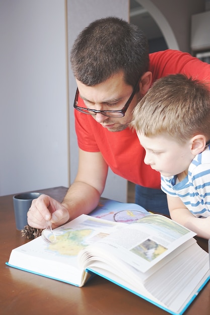 Close up on dad helping his son to learn geography at home