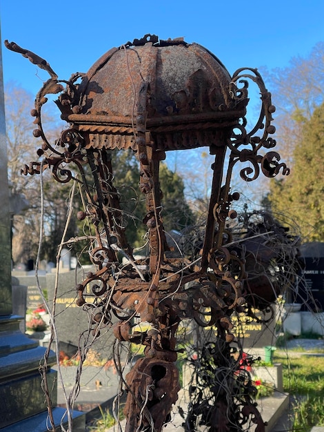 Close up of a decaying vintage metal lantern covered in rust at graveyard