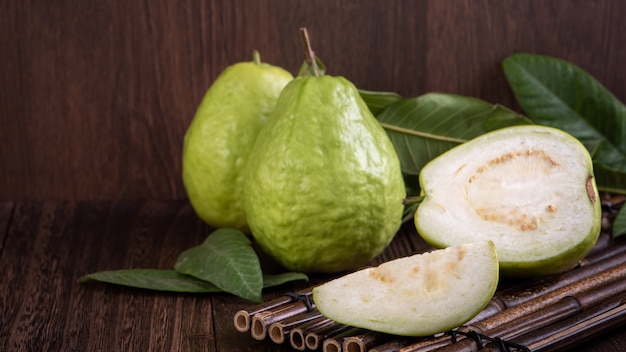 Close up of delicious beautiful guava set with fresh green leaves isolated.