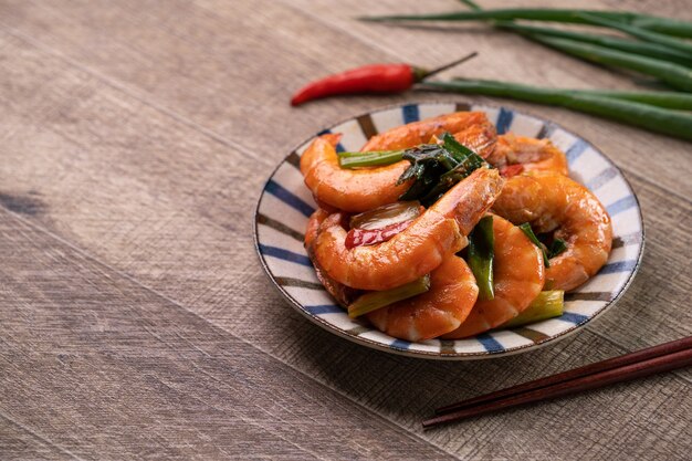 Close up of delicious homemade pan-fried shrimp in a plate on dark wooden table