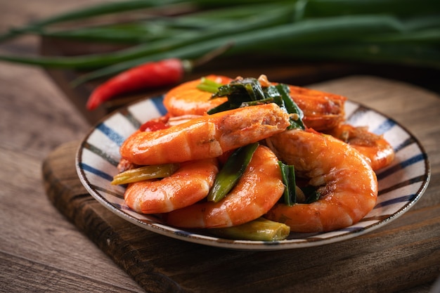 Close up of delicious homemade pan-fried shrimp in a plate on dark wooden table