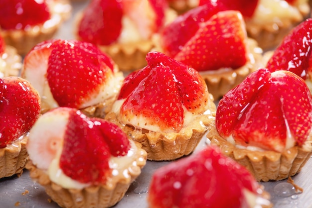 Close up of delicious tartlets with fresh strawberries and vanilla cream.