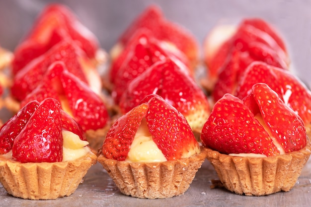 Close up of delicious tartlets with fresh strawberries and vanilla cream.