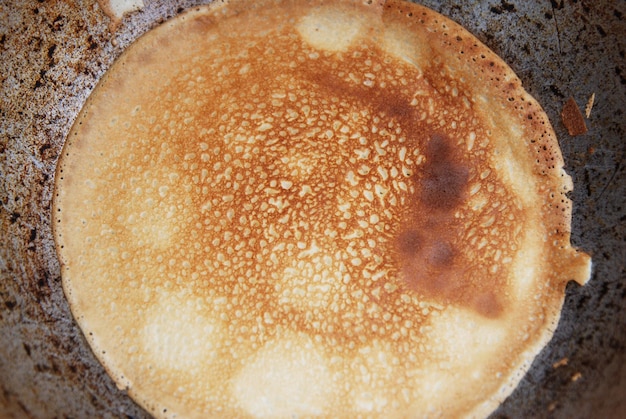 Close up of delicious thin pancakes on frying pan, top view