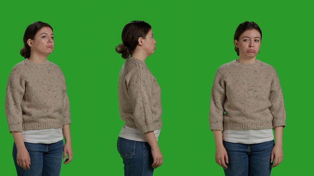 Close up of depressed model acting upset over greenscreen studio backdrop, being sad and displeased on camera. Negative discouraged person feeling discontent and disappointed, facial expressions.