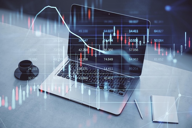 Close up of desktop with coffee cup notepad and laptop glowing candlestick forex chart and map hologram on blurry background Stock investment market and money concept Double exposure