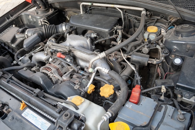 Close up detail of a Flat-four (boxer) car engine under the open hood. Diagonal view.