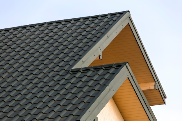 Close-up detail of new modern house top with shingled green roof 