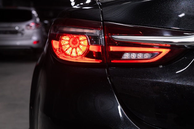 Close up detail on one of the LED black taillight modern red crossover car. Exterior detail automobile.