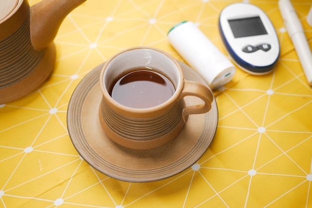 Close up of diabetic measurement tools and green tea on yellow background