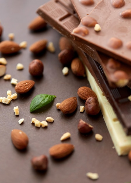 Photo close up of different chocolate bars and nuts