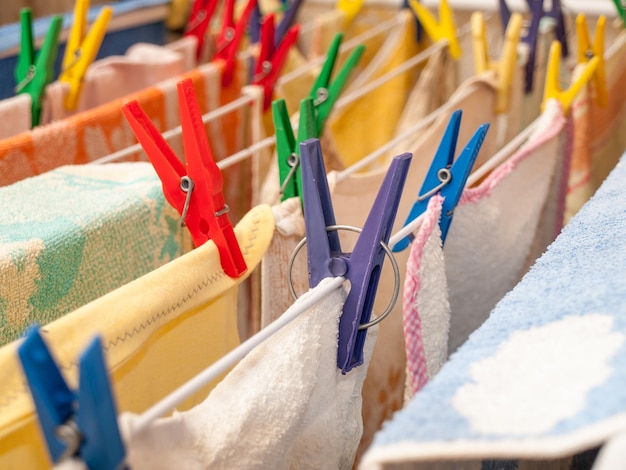 Close up of different plastic clothespins on a clotheshorse with linen. Laundry concept. Shallow depth of field.