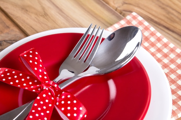 close up dinner setting fork and spoon on plate on wooden background