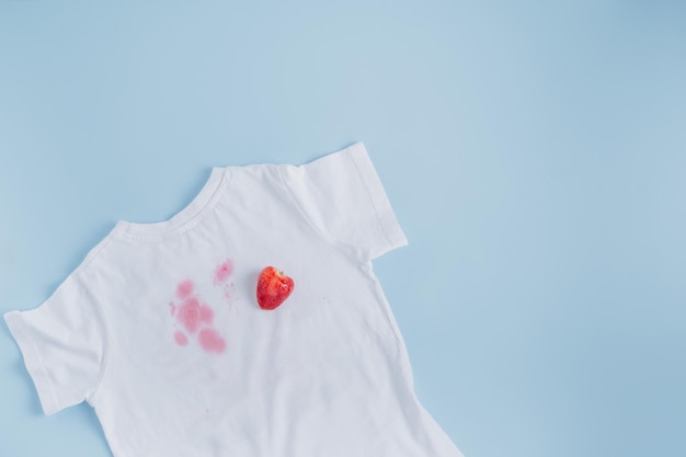 close up dirty stain of strawberry on a white shirt