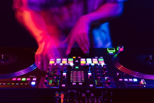 Close up of dj hands on dj console mixer during concert in the club