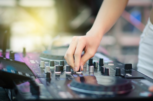 Close up of DJ's hand playing music at turntable on a party festival