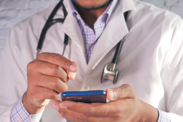 Close up of doctor hand using smartphone in the hospital.