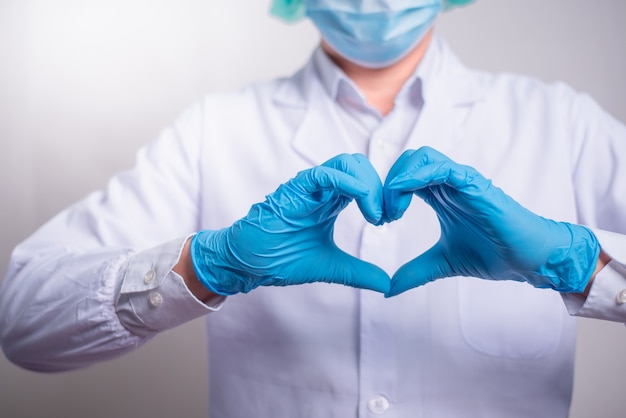 Close up of Doctor hands in gloves making shape of heart, Medicine and Healthcare Concept.