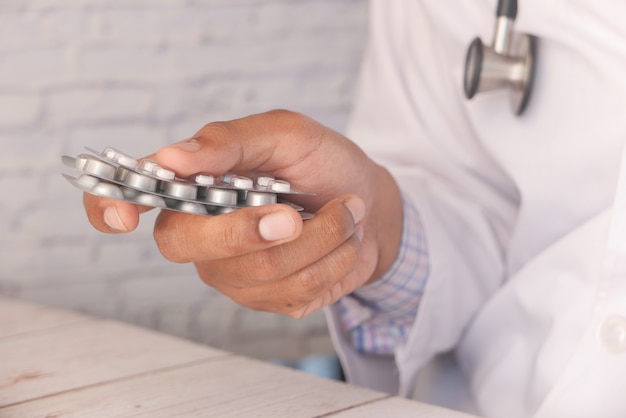 Close up of doctor holding blister packs .