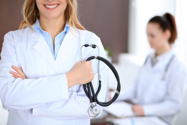 Close up of a doctor holding a stethoscope in his hand while standing in medical office