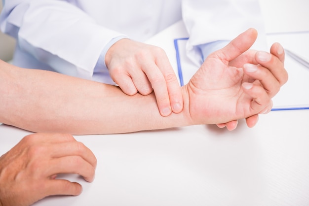 Close-up of doctor measuring pulse of his patient.