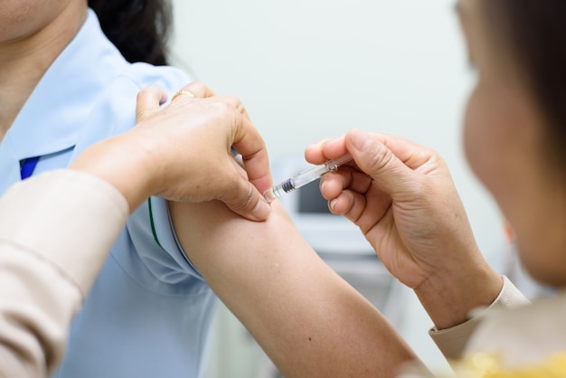 Close up doctor's hand injecting for vaccination in the shoulder patient