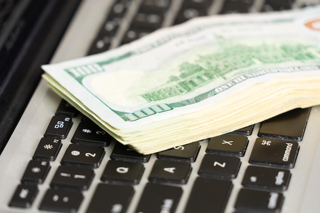 Close up of dollar banknotes on laptop keyboard business concept