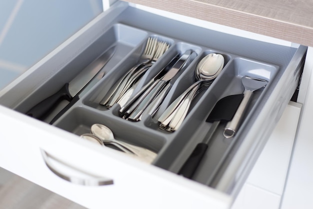 Close up of drawer with cutlery in modern kitchen