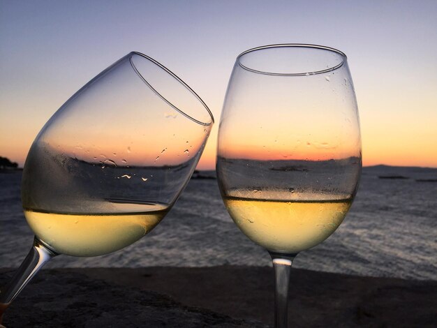 Close-up of drink against clear sky during sunset